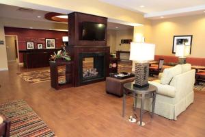 a living room with a couch and a fireplace at Hampton Inn Milan in Milan