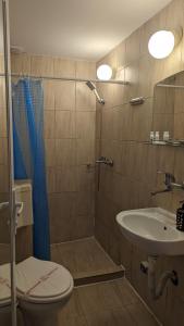 y baño con ducha, aseo y lavamanos. en Guest House Chalakov, en Sinemorets