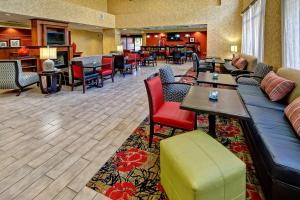 a hotel lobby with a couch and tables and chairs at Hampton Inn Quincy in Quincy