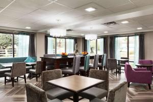 a dining room with tables and chairs and windows at Hampton Inn Waycross in Waycross