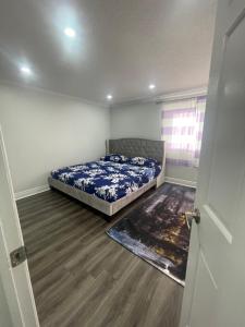 ein Schlafzimmer mit einem Bett in der Ecke eines Zimmers in der Unterkunft Mo's Place in Mississauga