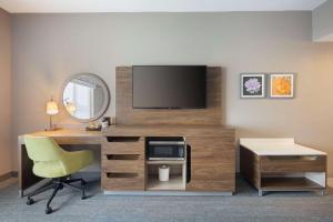 Habitación de hotel con escritorio, TV y silla. en Hampton Inn Clovis, Nm en Clovis