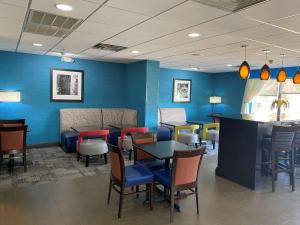 un restaurante con paredes azules, mesas y sillas en Hampton Inn Ft. Chiswell-Max Meadows, en Max Meadows
