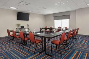 a conference room with a black table and red chairs at Hampton Inn Augusta in Augusta