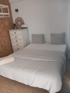two twin beds in a bedroom with a dresser at Costa by the Beach in Costa da Caparica