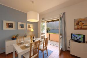a dining room with a table and chairs and a television at La Spiaggia in Oliveto Lario