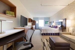a large hotel room with a bed and a couch at Home2 Suites By Hilton Oklahoma City Quail Springs in Oklahoma City