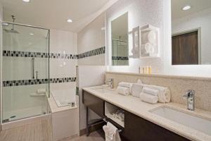 a bathroom with two sinks and a glass shower at Hampton Inn & Suites Lubbock University, Tx in Lubbock