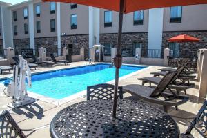 uma piscina com cadeiras e uma mesa com um guarda-sol em Hampton Inn Hartwell Ga em Hartwell