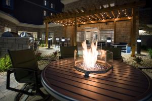 a wooden table with a fire pit on a patio at Homewood Suites By Hilton Paducah in Paducah