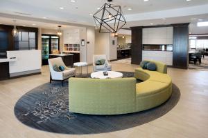 eine Lobby mit einem Sofa, einem Tisch und Stühlen in der Unterkunft Homewood Suites By Hilton Paducah in Paducah