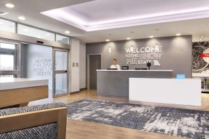 a woman standing at a welcome desk in a lobby at Hampton Inn & Suites St Charles Old Town Area, Mo in St. Charles