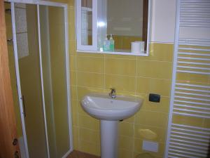 y baño con lavabo y espejo. en La Barmo Affittacamere, en Pietraporzio