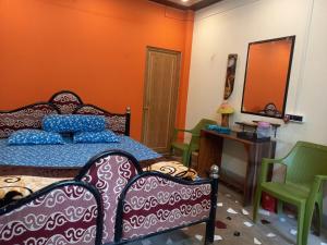 um quarto com uma cama, cadeiras e um espelho em Atmaja The Cottage Garden Home Stay Malda Under Tourism Department Government of West Bengal em Māldah