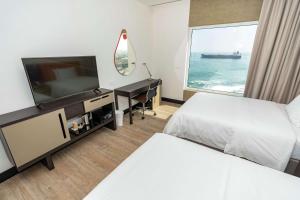 a hotel room with two beds and a flat screen tv at Hampton By Hilton Antofagasta in Antofagasta