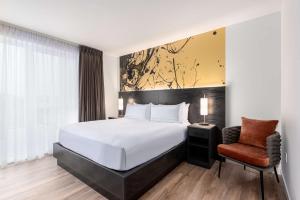 um quarto de hotel com uma cama e uma cadeira em Holman Riverfront Park Hotel Salem, Tapestry By Hilton em Salem