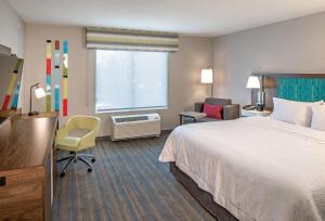 哥伦布市Hampton Inn Columbus的一间带床、书桌和窗户的酒店房间 更多5张照片