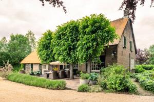 an old house with a tree in front of it at Filion's Place in Roosendaal