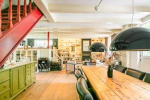 a dining room with a wooden table and green cabinets at Filion's Place in Roosendaal