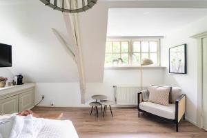 a white living room with a chair and a window at Filion's Place in Roosendaal