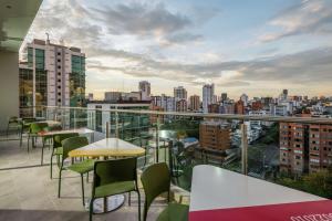 a balcony with tables and chairs and a city skyline at Hampton By Hilton Bucaramanga in Bucaramanga