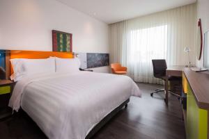 a hotel room with a large bed and a desk at Hampton By Hilton Bucaramanga in Bucaramanga