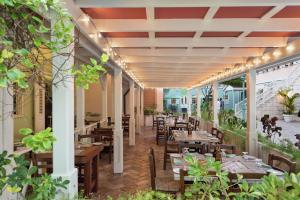 un restaurante con mesas de madera, sillas y luces en Hilton Grand Vacations Club The Crane Barbados, en Saint Phillip