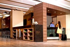 two people standing in a hotel lobby with their luggage at Hampton by Hilton Barranquilla in Barranquilla