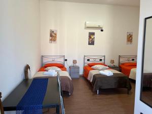 sypialnia z 2 łóżkami i stołem w obiekcie B&B Piandelidei w mieście Sassari