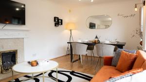 uma sala de estar com um sofá, uma mesa e uma lareira em The Cosy Corner em Loughton