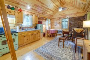 a kitchen and dining room in a log cabin at Marlinton Cabin Rental with Greenbrier River Access! in Marlinton