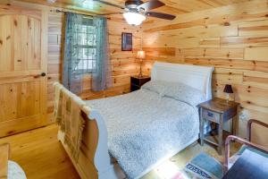 a bedroom with a bed in a log cabin at Marlinton Cabin Rental with Greenbrier River Access! in Marlinton
