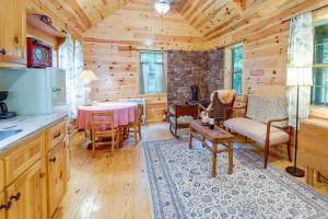 a kitchen and dining room in a log cabin at Marlinton Cabin Rental with Greenbrier River Access! in Marlinton