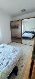 a bedroom with a bed and a mirror at Family apartment with garden in Sarajevo