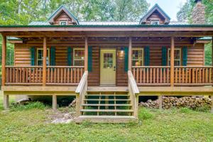 a log cabin with a large porch and a deck at Marlinton Cabin Rental with Greenbrier River Access! in Marlinton +18 photos