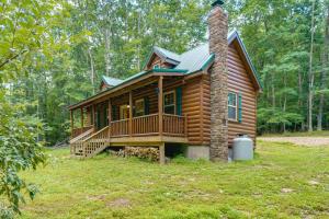 a log cabin with a porch and a chimney at Marlinton Cabin Rental with Greenbrier River Access! in Marlinton