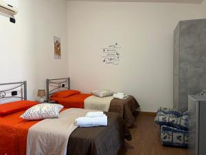 Habitación con 2 camas y sábanas de color naranja y marrón. en B&B Piandelidei, en Sassari