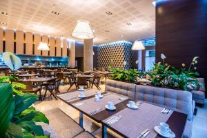 un ristorante con tavoli e sedie in legno e piante di Hilton DoubleTree Bogotá Salitre AR a Bogotá