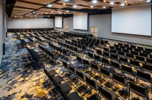 an empty lecture hall with chairs and a projection screen at Hilton DoubleTree Bogotá Salitre AR in Bogotá