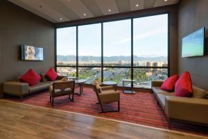 - un salon avec des canapés, des chaises et de grandes fenêtres dans l'établissement Hampton By Hilton Bogota Airport, à Bogotá