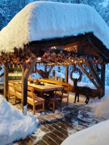 a snow covered pavilion with a table and benches at Chalet de Creytoral in Arâches-la-Frasse