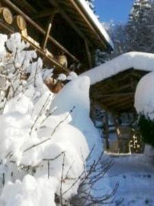 un patio cubierto de nieve junto a una casa en Chalet de Creytoral en Arâches-la-Frasse