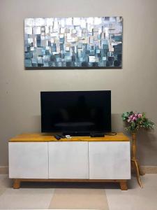 a tv sitting on top of a white cabinet at Cozy studio apartment in Dar es Salaam