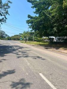 una calle vacía con árboles a un lado de la carretera en Cozy studio apartment, en Dar es Salaam