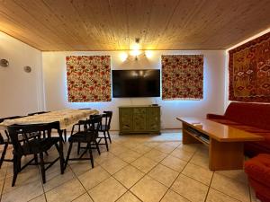 ein Wohnzimmer mit einem Tisch, Stühlen und einem Sofa in der Unterkunft Ginkgo House in Kehidakustány