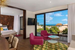 a hotel room with a view of the ocean at The Fives Downtown Hotel & Residences, Curio Collection by Hilton in Playa del Carmen