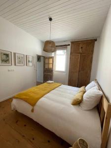 Een bed of bedden in een kamer bij Le Fourbiel - Maison de village atypique