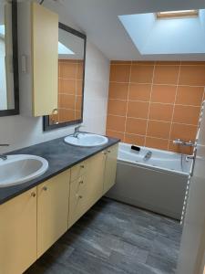 a bathroom with two sinks and a tub and a mirror at Maison pour 1 à 6 personnes in Talmont-Saint-Hilaire
