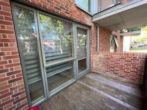 a screened porch with sliding glass doors on a brick building at Spacious 2 Bedroom Modern Flat in London