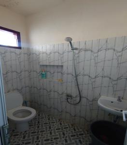 y baño con ducha, aseo y lavamanos. en Mawar Homestay en Banda Aceh
